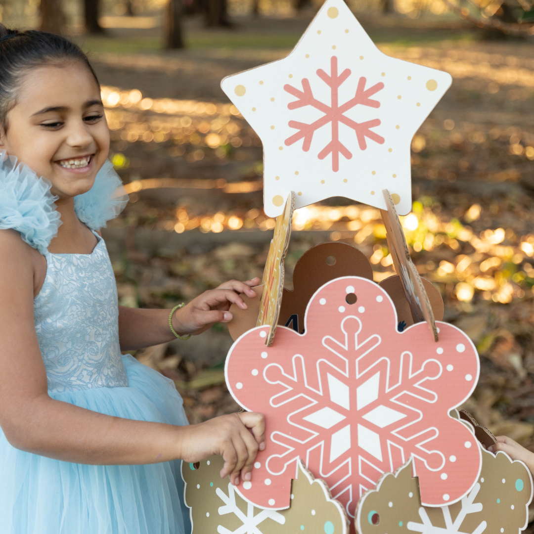 girl building a cardboard xmas tree