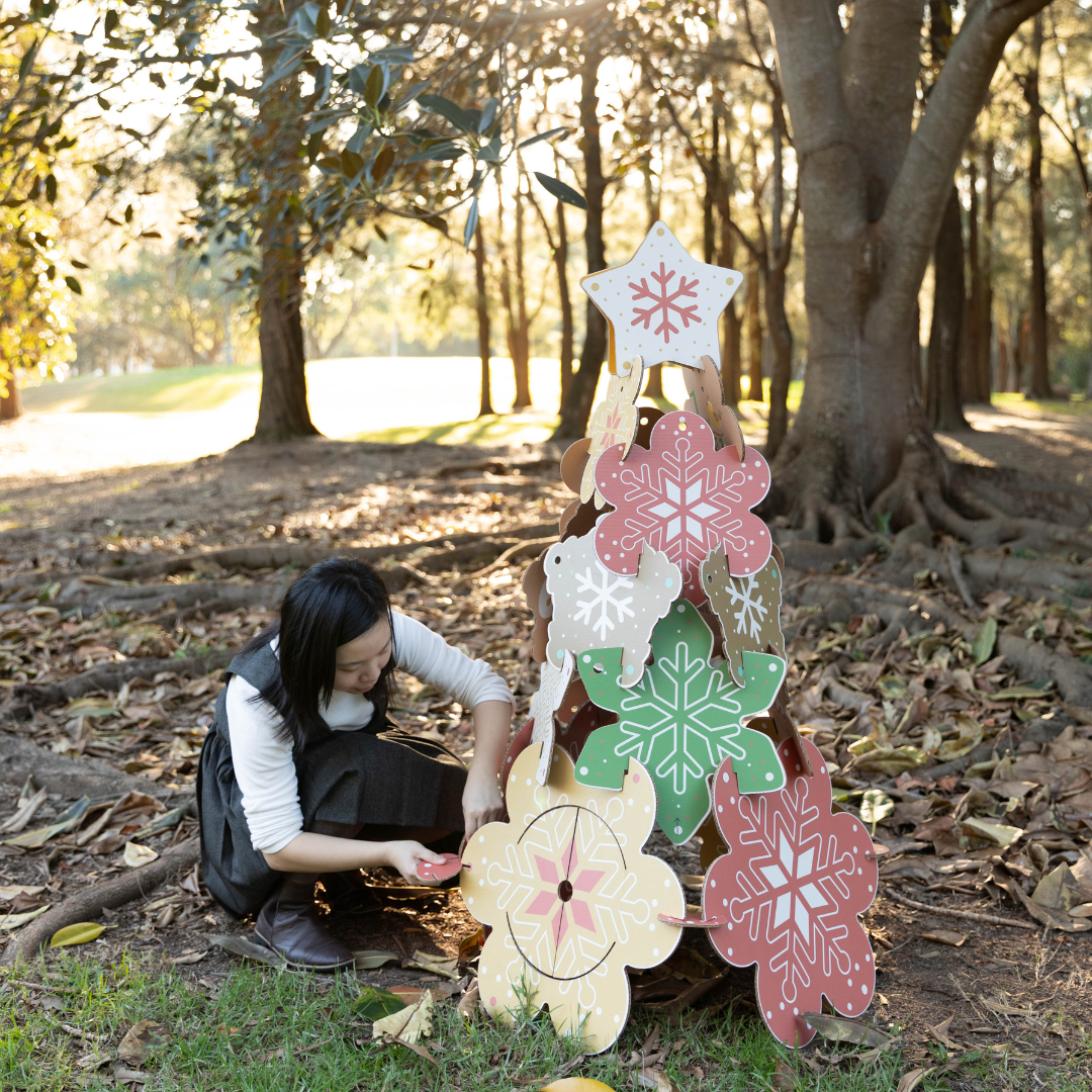 woman building a cardboard Christmas tree